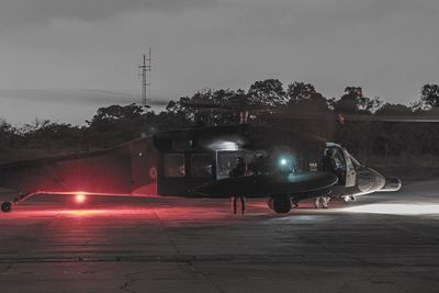 Illuminated cars on road against sky