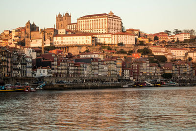 Boats in river with city in background