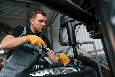 Employee at work. man in uniform is in the auto service.