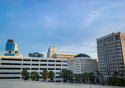 Buildings in city against cloudy sky