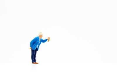 Side view of man standing against blue background
