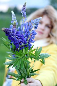 Portrait of woman with purple flowering plant