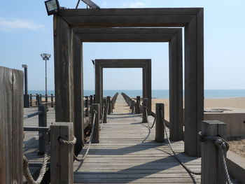Wooden pier on sea against sky