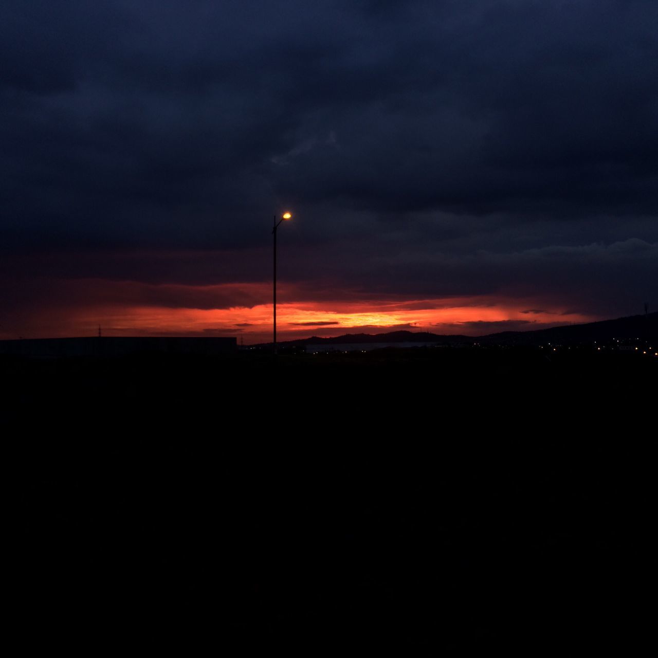 VIEW OF ILLUMINATED STREET LIGHT AGAINST CLOUDY SKY