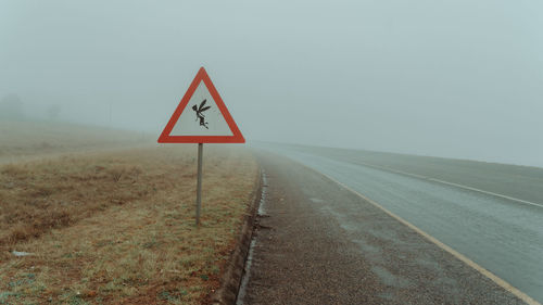 Road sign against sky