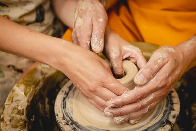 Cropped hands of potter making pot