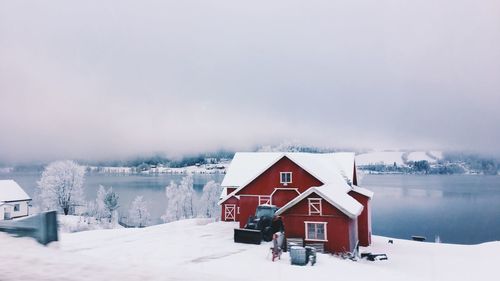 House on snow covered land against sky