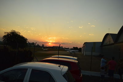 Cars on road against sky during sunset