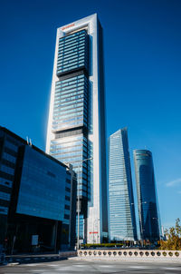 Low angle view of modern buildings against blue sky