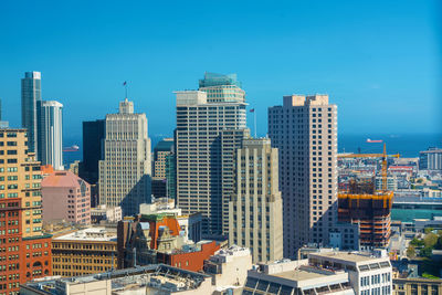 Modern buildings in city against blue sky