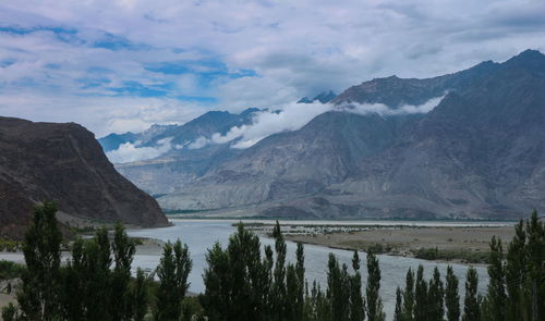 Scenic view of lake by mountains against sky