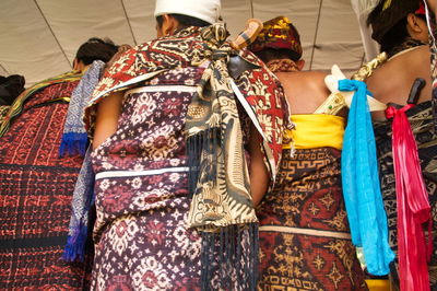 Low section of woman with multi colored umbrellas