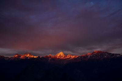 Scenic view of mountains against cloudy sky during sunset