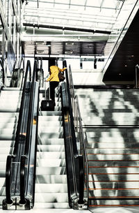 Rear view of man on escalator