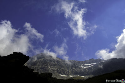 Low angle view of snowcapped mountains against sky