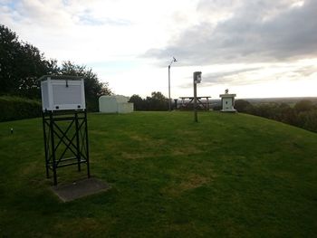 Scenic view of grassy field against cloudy sky