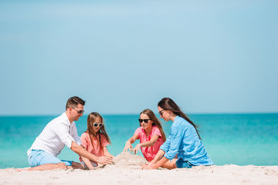 People on beach against clear sky