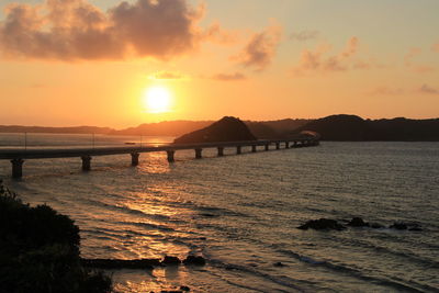 Tsunoshima ohashi bridge over sea against sky during sunset