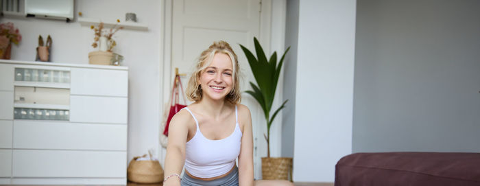 Portrait of young woman sitting at home