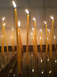 Close-up of illuminated candles in church at night