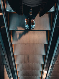 Low section of man standing on escalator