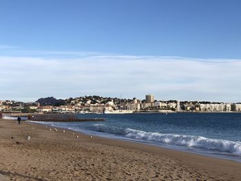 Scenic view of beach against sky in city