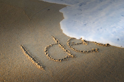 High angle view of text on sand at beach