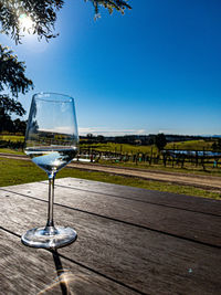 Glass of wine on table against clear sky