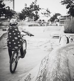 Rear view of man riding bicycle on road