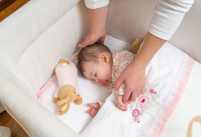 High angle view of baby sleeping on bed