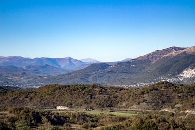Scenic view of mountains against clear blue sky
