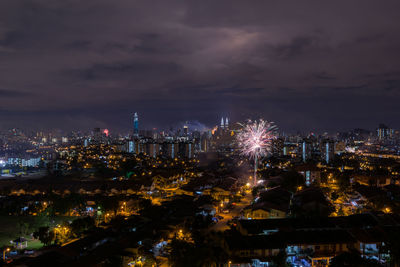 Illuminated cityscape against sky at night