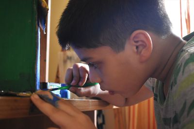 Portrait of boy holding camera at home