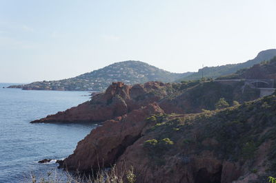 Scenic view of sea and mountains against clear sky