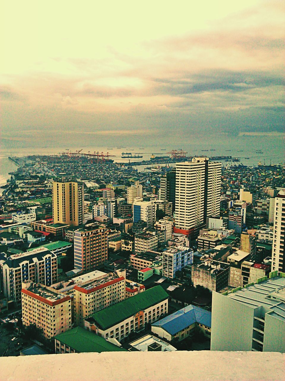 building exterior, architecture, cityscape, city, built structure, sea, sky, water, horizon over water, skyscraper, crowded, high angle view, cloud - sky, residential district, residential building, modern, tower, residential structure, tall - high, cloud