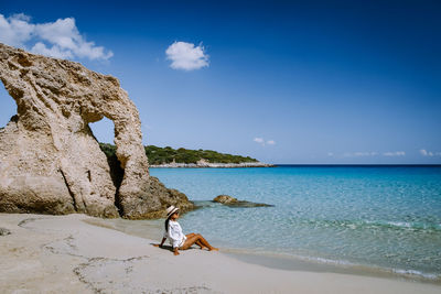 Man on beach against blue sky
