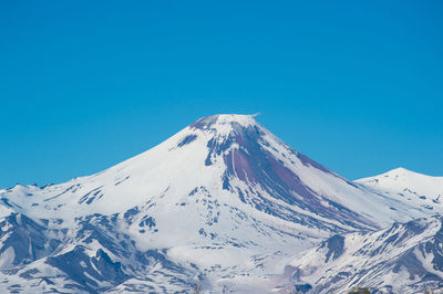 Scenic view of snowcapped mountains against clear blue sky