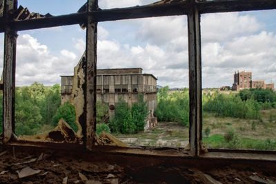 Abandoned building on field against sky