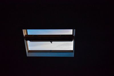 Low angle view of glass window against sky