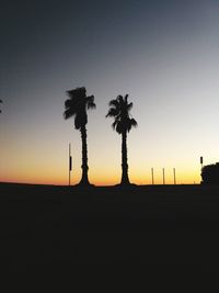 Silhouette trees on field against sky during sunset