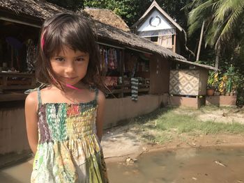 Portrait of girl standing outside house