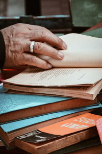 Close-up of hand reading book at table