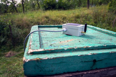 Close-up of old rusty container on field