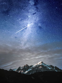 Scenic view of snowcapped mountains against sky at night