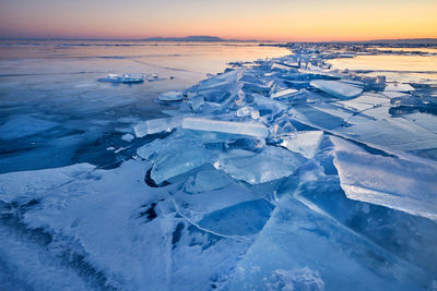 Aerial view of frozen sea against sky during sunset