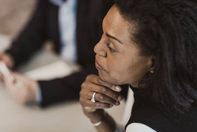 High angle view of businesswoman with hand on chin in corporate training
