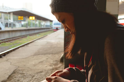 Woman sitting at railroad station