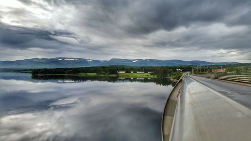 Scenic view of lake by mountain against sky