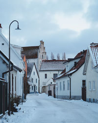 Snow covered houses against sky