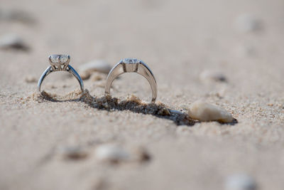 Close-up of wedding rings on sand